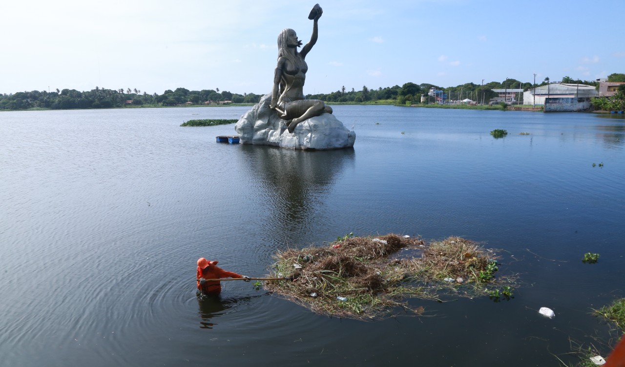 operário limpando a lagoa de messejana próximo à estátua de Iracema